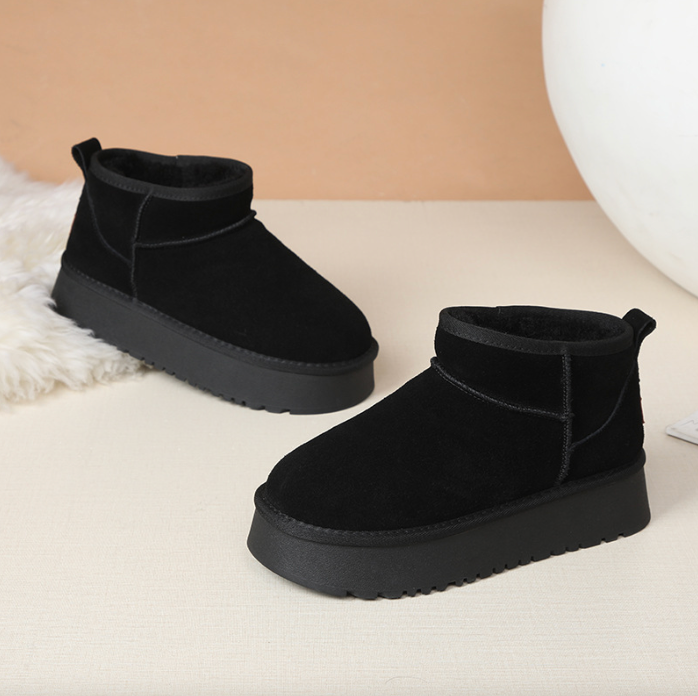 Black suede ankle boots with a textured sole, set against a neutral background.