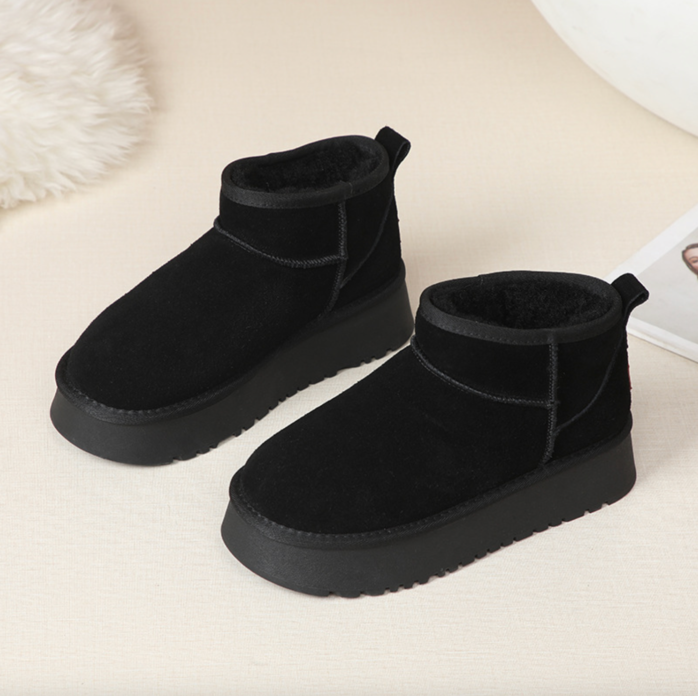 Black suede ankle boots with a flat sole and soft interior, displayed on a neutral background.